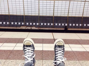 Low section of woman standing on tiled floor