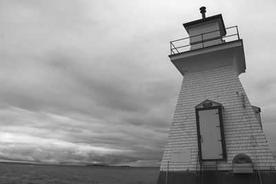 Low angle view of lighthouse by sea against sky