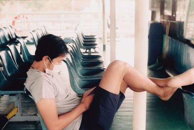 Midsection of young woman sitting on chair