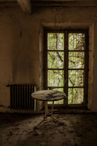 Empty chairs and table in abandoned room