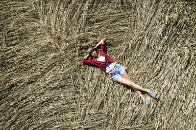 Portrait of woman lying on hay