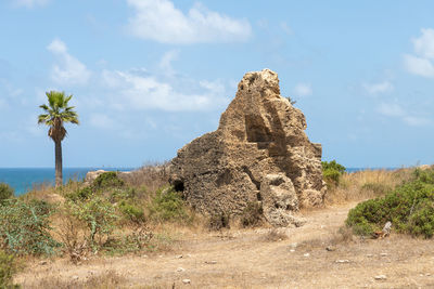 Rock formations in sea against sky