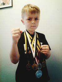 Portrait of boy standing against wall