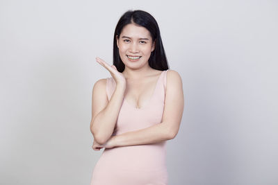 Portrait of a smiling young woman against white background