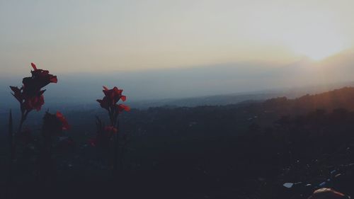 Silhouette people on mountain against sky during sunset