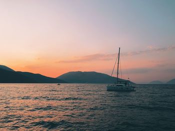 Sailboat on sea against sky during sunset