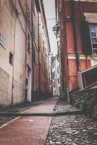 Empty alley amidst buildings in city