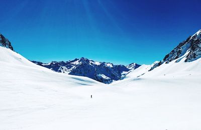 Scenic view of snow covered mountains against clear blue sky
