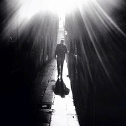 Rear view of woman walking on road