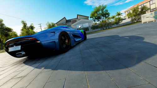 Car on street in city against blue sky