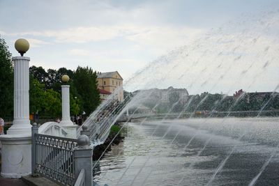 Fountain in street against sky