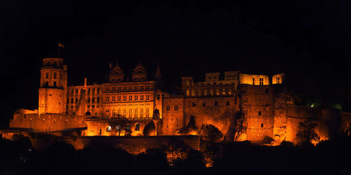 Illuminated buildings against sky at night