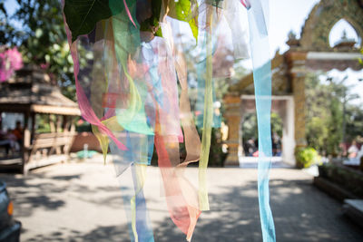 Reflection of woman in multi colored umbrella in city street