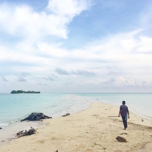 Rear view of a man walking on beach