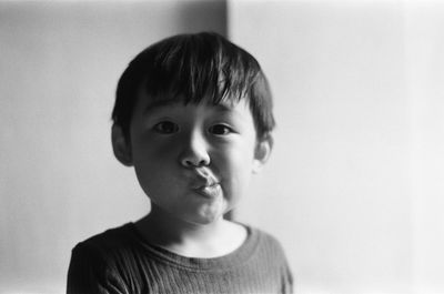 Portrait of boy standing against wall