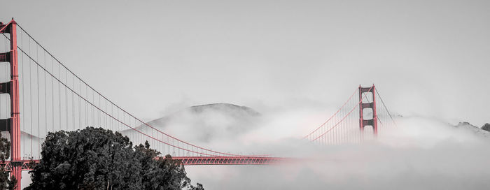 Low angle view of suspension bridge against sky