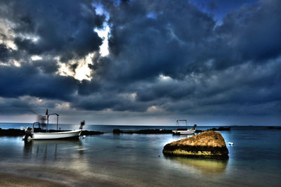 Sailboats on sea against dramatic sky