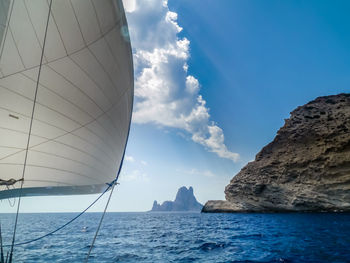 Sailboats sailing on sea against blue sky