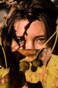 Close-up portrait of teenage girl by leaves during autumn