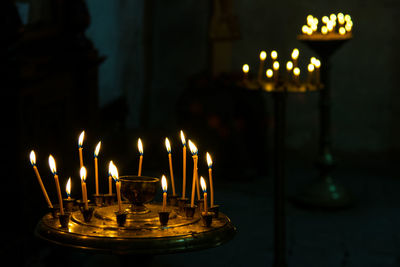 Close-up of illuminated candles in temple