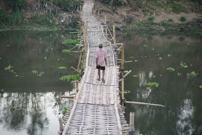 Rear view of man standing by lake