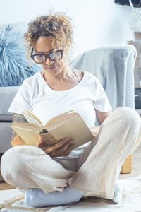 Young woman sitting on sofa at home