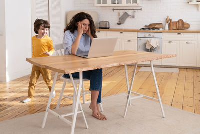 Women standing on table at home