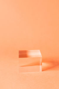 Close-up of white candle on table against wall