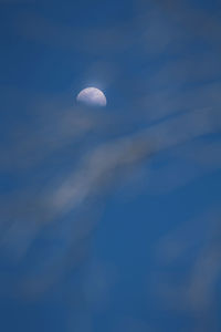 Low angle view of moon against blue sky at night