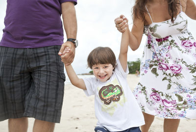 Parents walking with son on beach