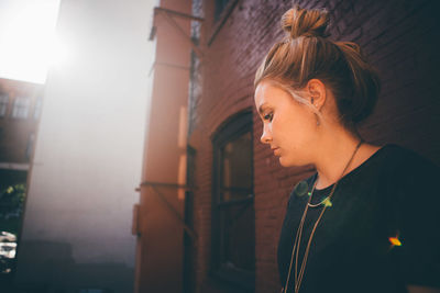 Close-up of young woman standing against building