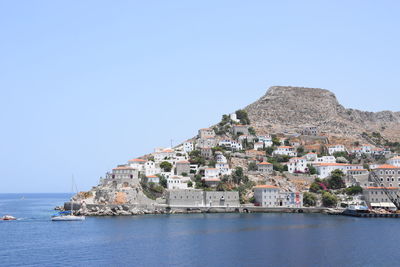 Scenic view of sea and buildings against clear sky