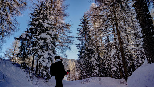 Rear view of man standing on snow covered land