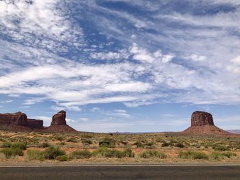 Rock formations on landscape against cloudy sky, monument valley 