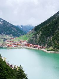 Scenic view of river by mountains against sky