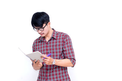 Young woman using mobile phone against white background