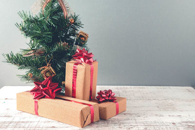 Christmas presents on wooden table against gray wall