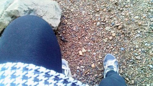 Low section of person standing on pebbles