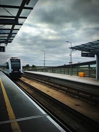 Train at railroad station against sky