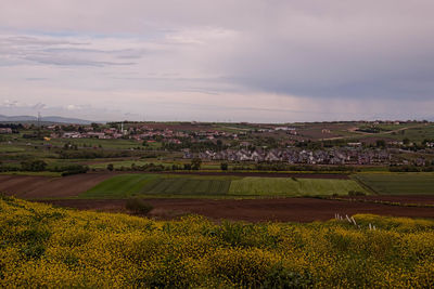 Scenic view of field against cloudy sky