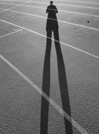 Shadow of man standing on running track