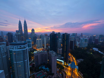 High angle view of city lit up at sunset