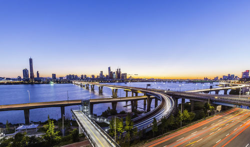 Bridge over river in city against sky