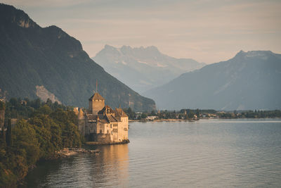 Scenic view of lake by buildings against mountains