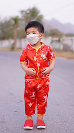 Boy wearing mask standing on road