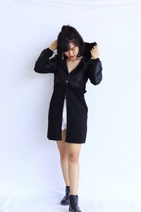 Full length portrait of woman standing against white background