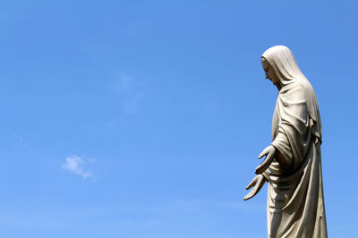 Low angle view of statue against blue sky