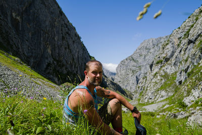 Male hiker in the mountains sitting looking at camera