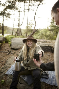 Smiling woman holding thermos