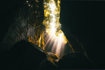 Sunlight streaming through rocks in water